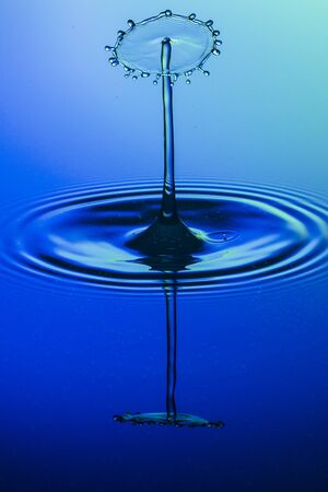 water drop collision on a blue backgroundの写真素材