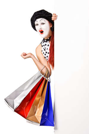Pretty mime woman holding blank billboard and shopping bags  Isolated on white background の写真素材