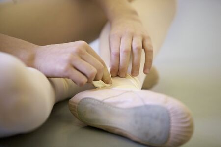 Young Ballerina Adjusting her shoeの写真素材