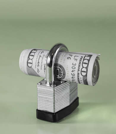 Roll of $100 Bills in Padlock (green background)の写真素材