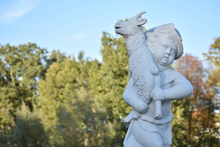 Statue of a child with a goat in the garden at schloss Charlottenburg palace in Berlinの写真素材