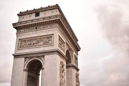 Arc de Triomphe with smoke in the background on an overcast day in Paris