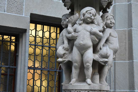 Stone statue of naked toddler girls on a building in Zurichのeditorial素材