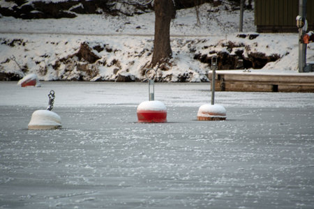 Landscape of red buoys in a frozen river in Stockholm Swedenの写真素材