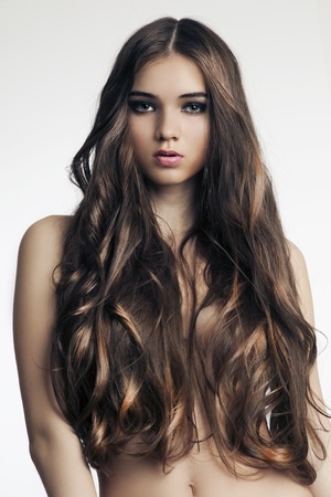 beautiful woman with perfect skin and long curly hair on a white backgroundの写真素材