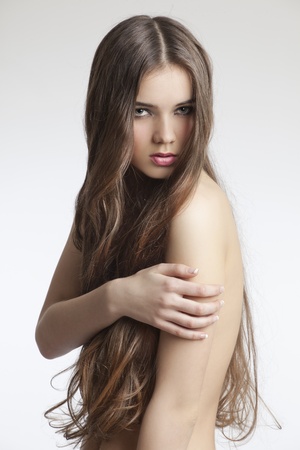 beautiful woman with perfect skin and long curly hair on a white backgroundの写真素材