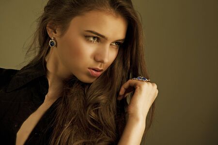 portrait of a beautiful woman with long hair in jewelryの写真素材