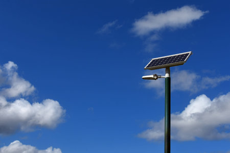 Solar electricity panel on a pole with a blue sky background