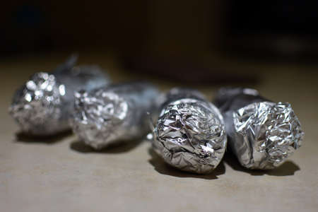 Vegetables wrapped in aluminium foil backgroundの写真素材