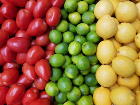 Lemons, limes, and tomatoes display backgroundの写真素材