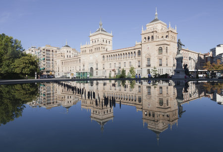 Valladolid, Spain, August 25th, 2010. Cavalry Academy, in the center of the city of Valladolid, in a place with people walking around the source that reflects the building of the Academy. In this square begins the main street of the cityのeditorial素材