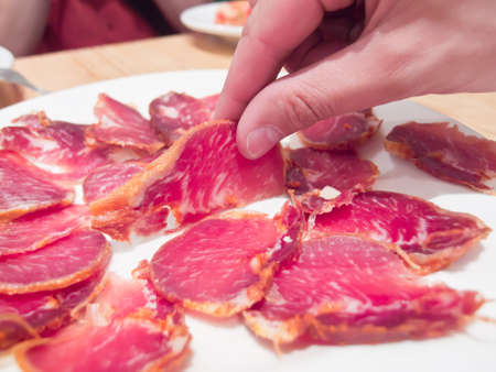 a hand grabbing a slice of tenderloin dish  の写真素材