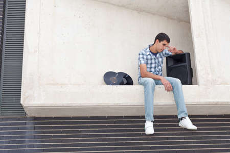 thoughtful young DJ, with his records and amp sitting in a window  の写真素材