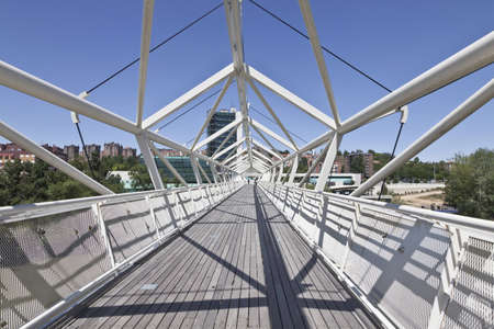 Valladolid, Spain, June 13, 2011. Footbridge hexagonal, some passers-by on the river Pisuerga with the Museum of Science to the bottom, forming a unique architectural complex designed by architect Rafael Moneo, Julio Martinez and Enrique de Teresaのeditorial素材