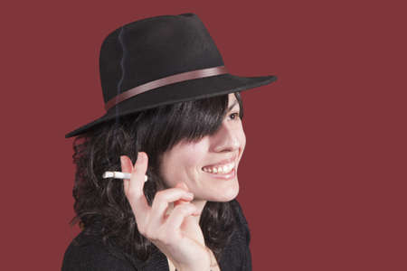 young girl with hat and cigar in handの写真素材