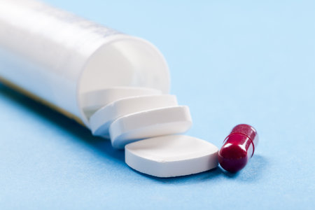 tube with white pills and a red pill in the pharmacy