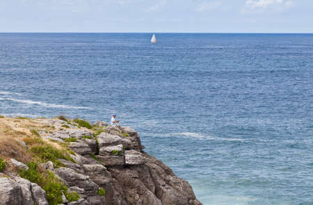 Lone fisherman on the Cantabrian coast cliffの写真素材