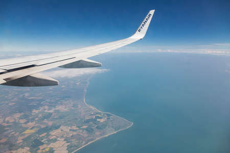 Wing of a Ryanair aircraft, flying over the coast of Great Britainのeditorial素材
