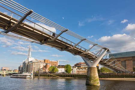 London, UK - May 16, 2016; Millennium Bridge, on the bank of the modern Tate Gallery, with the skyscraper called The Shard in the background and the moon in the skyのeditorial素材