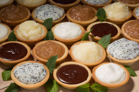 Tartlets on the table, assortment with different creamsの写真素材