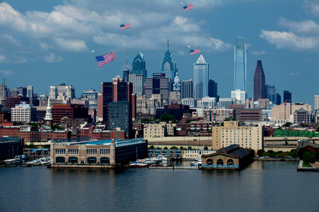 Skydivers parashoot into downtown Philadelphia Pennsylvania with giant American Flags attached to...