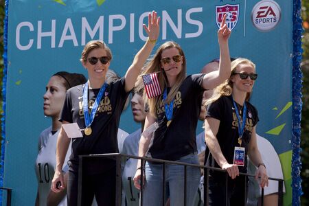 U.S. women's soccer team wave to the crowd as their float makes it way up Broadway's Canyon of Heroes during the ticker tape parade to celebrate the U.S. women's soccer team FIFA World Cup victory in downtown New York Cityのeditorial素材