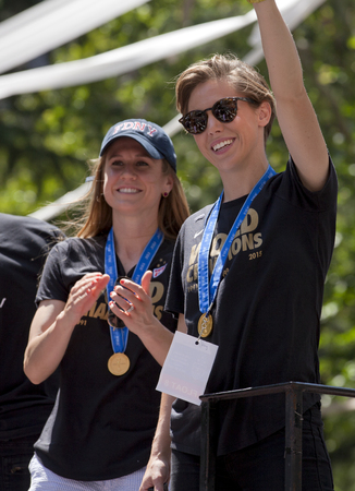 U.S. women's soccer team wave to the crowd as their float makes it way up Broadway's Canyon of Heroes during the ticker tape parade to celebrate the U.S. women's soccer team FIFA World Cup victory in downtown New York Cityのeditorial素材