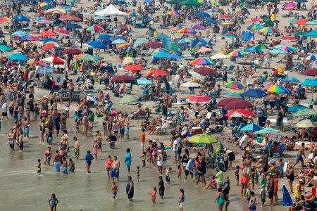 Beach crowded with sunbathers and swimmers in Atlantic City on a warm summer day in July. Atlantic City, New Jersey is a popular summer time vacation destination and local retreat on the east coast of the United States.のeditorial素材