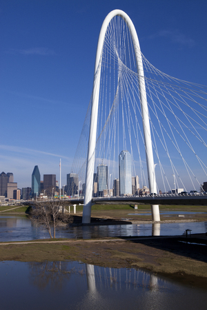 The new Margaret Hunt Hill Bridge that crosses the Trinity River with downtown Dallas, Texas in the background. The bridge uses a unique design of a 400-foot steel arch and cables to suport the bridge.のeditorial素材