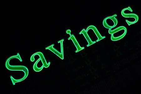 Green neon sign of "Savings" at nightの写真素材