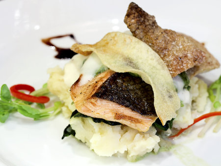 Salmon steak with vegetables on white dish 