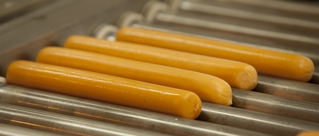 Nicely grilled sausages on the steel hot roll.の写真素材