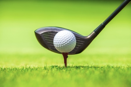 Golf ball behind driver at driving range, plenty of copy-space and very shallow depth of field の写真素材