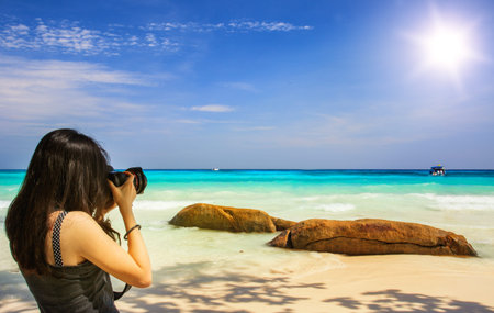  Cheerful girl talking pictures with digital camera at tachai beach phuket
