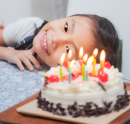 Portrait of little pretty girl with birthday cakeの写真素材