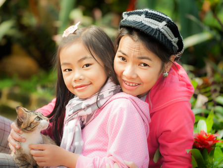 Young mother and her cute girl have fun ingreen gardentの写真素材