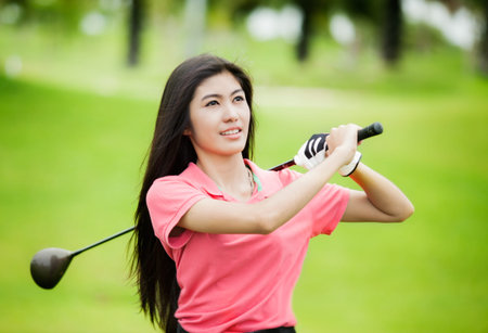 Asia girl golf player with green backgroundの写真素材