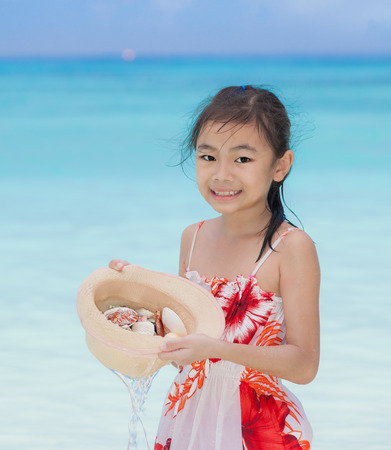 Asia tourist girl holding had and starfish and shell in tropical beachの写真素材