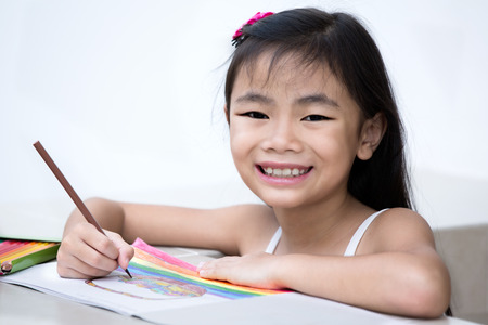 Lovely girl working on her school  drawing homework at homeの写真素材