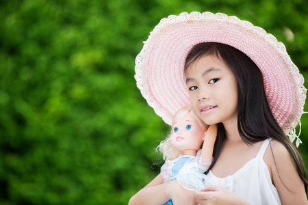 Cute Asian girl with dollの写真素材