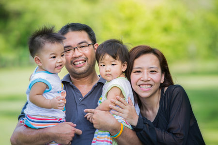 Happy asia mother, father and daughter in the parkの写真素材