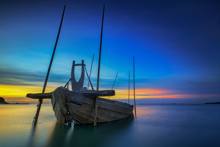 Fishing boat beached with sunset viewの写真素材