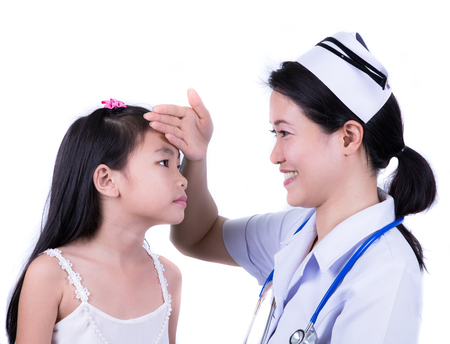 Happy little girl at the nurse for a checkup - being examined with a stethoscopeの写真素材