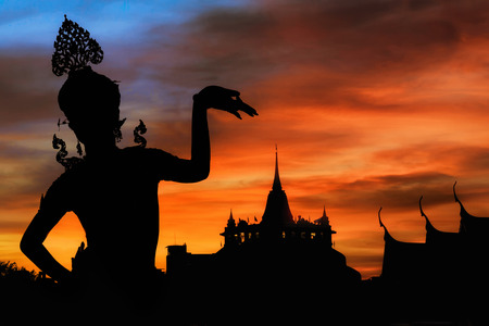 thai dance woman with temple and pagoda in thailand background silhouetteの写真素材