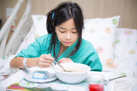 Woman patient in hospital bed  from cold and eating food for patient personの写真素材