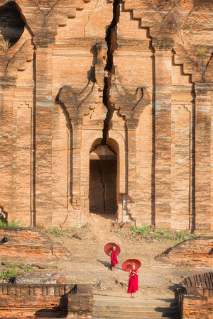 Buddhist novice are walking in oil and damage Pagoda in  temple in mingun, Bagan, Mandakay , Myanmarの写真素材