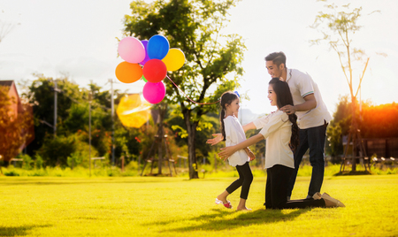 Daughter running to mother and father, She enjoyed the play balloonsの写真素材