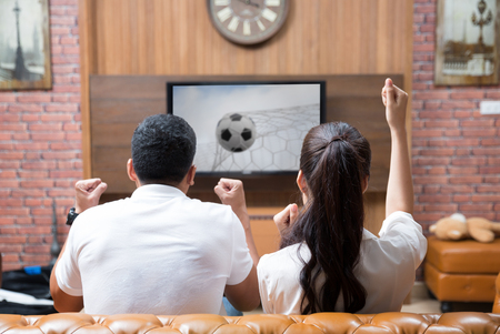 Asian Couple having fun watching soccer gameの写真素材
