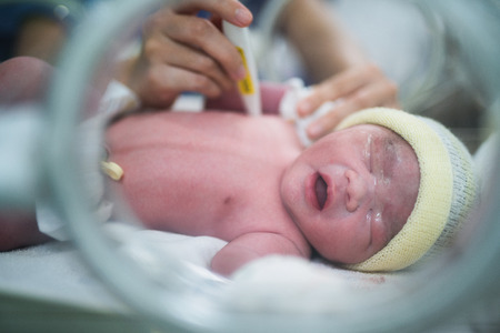 Body temperature check for new born baby in hospital, mother and baby conceptの写真素材