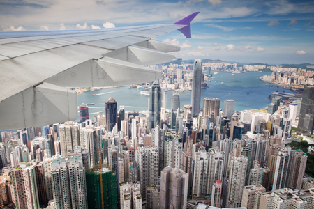 Top view of Hong kong, Kowlon and wing of airplane from window of airplane just take off from Hongkong international airport, Hongkong city, Chinaの写真素材